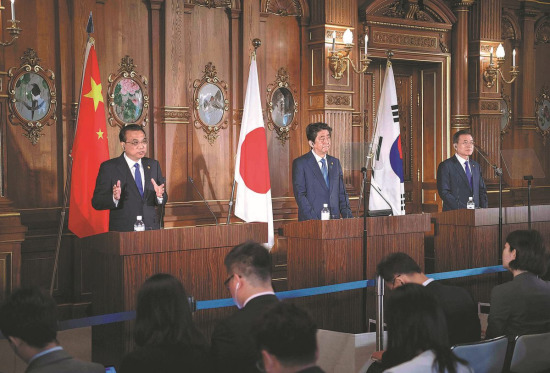 Premier Li Keqiang, Japanese Prime Minister Shinzo Abe (center) and South Korean President Moon Jae-in take questions from journalists after the seventh leaders' meeting in Tokyo on Wednesday. (LI TAO/XINHUA)